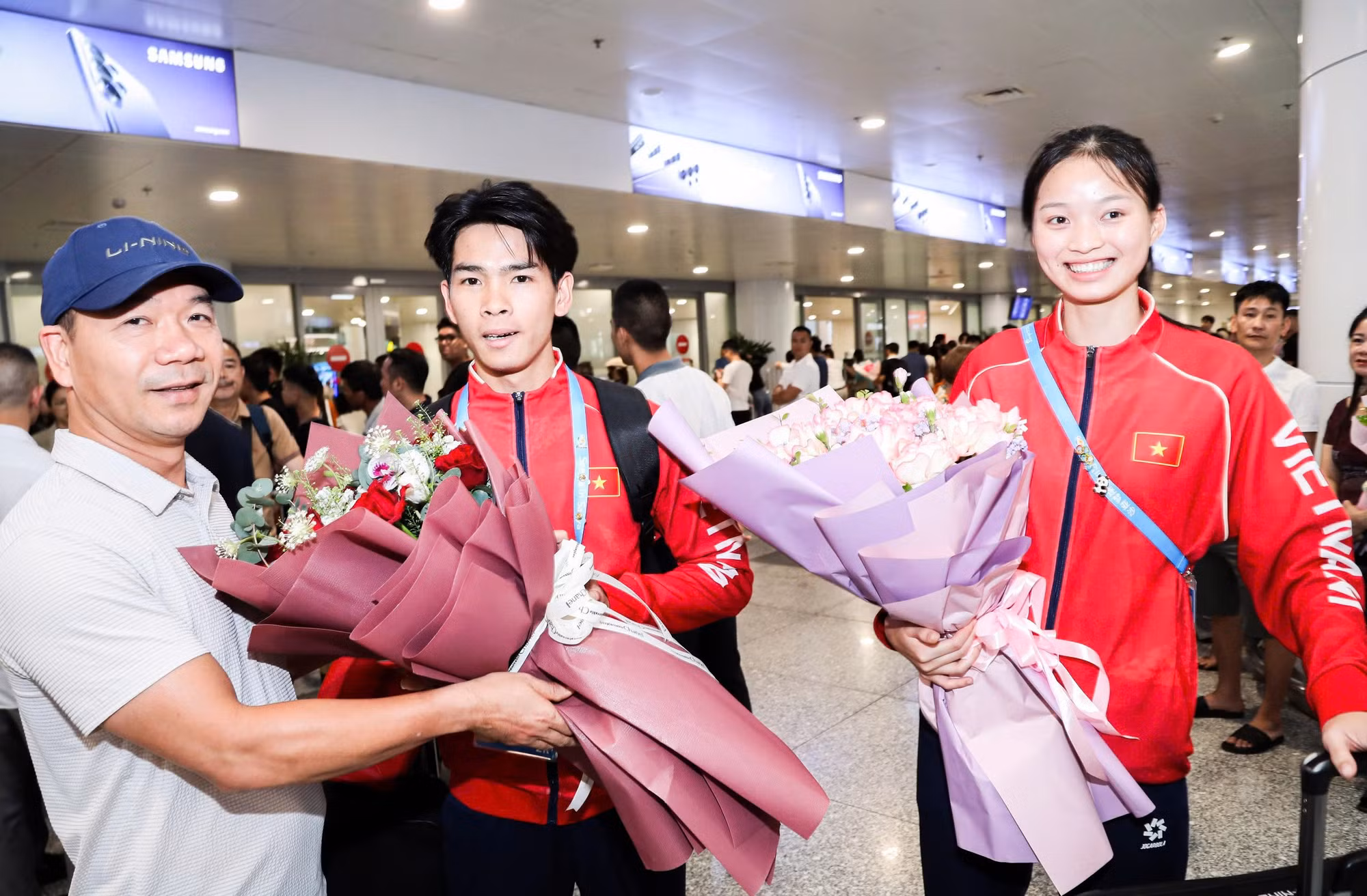 Ông Hoàng Quốc Vinh - Trưởng phòng Thể thao thành tích cao (Cục Thể dục thể thao Việt Nam) tặng hoa chúc mừng hai VĐV điền kinh xuất sắc giành huy chương vàng tại ABG6.